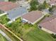 Aerial view of the backyard with a screened-in lanai with other neighboring properties and green lawns at 10927 Standing Stone Dr, Wimauma, FL 33598