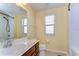 Bright bathroom with a single sink vanity, toilet, tiled shower and window at 11117 Abaco Island Ave, Riverview, FL 33579