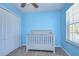 Bright bedroom showcasing a crib, closet and a window with natural light at 11117 Abaco Island Ave, Riverview, FL 33579