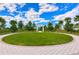 Well-manicured community green space with a white pergola, surrounded by lush trees and blue skies at 11117 Abaco Island Ave, Riverview, FL 33579