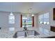 Kitchen island with granite countertops, pendant lighting, and view of outdoor patio through sliding glass doors at 11117 Abaco Island Ave, Riverview, FL 33579