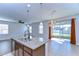 Granite kitchen island featuring a sink, pendant lighting, and view of outdoor space with sliding glass doors at 11117 Abaco Island Ave, Riverview, FL 33579