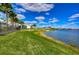 Expansive lakeside view featuring lush green lawns and palm trees along the water's edge in a serene community at 11117 Abaco Island Ave, Riverview, FL 33579