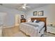 Bright bedroom with a view into the ensuite bathroom, ceiling fan, and decor at 16313 Treasure Point Dr, Wimauma, FL 33598