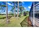 Beautiful backyard with lush lawn, mature trees, and a glimpse of the screened lanai at 18126 Kara Ct, Tampa, FL 33647