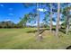 Lush green backyard with mature trees and a distant view of other homes at 18126 Kara Ct, Tampa, FL 33647