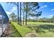Expansive backyard featuring lush green lawn and views of a serene golf course beyond mature trees at 18126 Kara Ct, Tampa, FL 33647