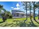 Backyard with a screened-in lanai, lush lawn, and well-maintained landscaping at 18126 Kara Ct, Tampa, FL 33647