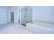 Bright bathroom featuring a tub, glass shower enclosure, and tile flooring at 18126 Kara Ct, Tampa, FL 33647