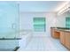 Bright bathroom featuring glass-enclosed shower, soaking tub, double vanity with tile flooring at 18126 Kara Ct, Tampa, FL 33647