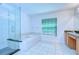 Bright bathroom showcases a glass-enclosed shower, tub, and double vanity with tile flooring at 18126 Kara Ct, Tampa, FL 33647