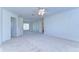 Bright carpeted bedroom featuring a ceiling fan and multiple doorways, enhancing space and functionality at 18126 Kara Ct, Tampa, FL 33647