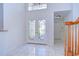 Spacious tiled foyer with decorative double doors and view of the staircase and entry to other rooms at 18126 Kara Ct, Tampa, FL 33647