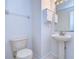 Compact half bathroom featuring a pedestal sink, a toilet, and a mirrored cabinet at 18126 Kara Ct, Tampa, FL 33647