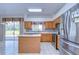 Well-lit kitchen featuring stainless steel appliances, an island, and tile flooring at 18126 Kara Ct, Tampa, FL 33647