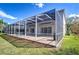 Spacious screened patio with tile flooring offers seamless indoor-outdoor living and views of the manicured lawn at 18126 Kara Ct, Tampa, FL 33647