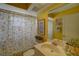 Bright bathroom featuring yellow walls, a floral shower curtain, and sink at 1875 Oak Branch Dr, Sarasota, FL 34232