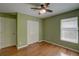 Bedroom featuring laminate floors, neutral walls, fan, closet, door and a window at 1875 Oak Branch Dr, Sarasota, FL 34232