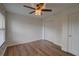 Bedroom featuring wood floors, fan, closet, window, and neutral walls at 1875 Oak Branch Dr, Sarasota, FL 34232