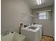 This efficient laundry room features a utility sink, shelving, and plenty of natural light at 1875 Oak Branch Dr, Sarasota, FL 34232