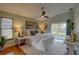 Bright main bedroom featuring a king bed, wood floors, ceiling fan, and sliding glass door at 1875 Oak Branch Dr, Sarasota, FL 34232