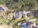 Overhead view of a house with a screened pool, set on a large lot with mature trees at 1902 Sweet Bay Ct, Plant City, FL 33566