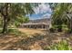 Serene backyard with large trees, lush greenery, and a glimpse of the screened pool area at 1902 Sweet Bay Ct, Plant City, FL 33566