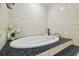 Spa-like bathroom showcasing a large tub with granite surround and tile walls at 1902 Sweet Bay Ct, Plant City, FL 33566