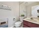 Neutral half bathroom featuring a maroon vanity, decorative wall art, and a spacious mirror at 1902 Sweet Bay Ct, Plant City, FL 33566