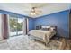 Modern bedroom boasts a sliding glass door, blue accent wall, and a large gray rug at 1902 Sweet Bay Ct, Plant City, FL 33566