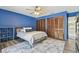 Comfortable bedroom with blue accent wall, two closets, and a gray patterned rug at 1902 Sweet Bay Ct, Plant City, FL 33566
