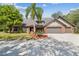 Charming brick home featuring a well-manicured lawn, mature landscaping, and a spacious three-car garage at 1902 Sweet Bay Ct, Plant City, FL 33566