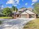 Beautiful brick home features a well-maintained lawn with mature landscaping and a three-car garage at 1902 Sweet Bay Ct, Plant City, FL 33566