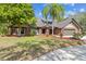 Beautiful brick home boasts a lush front yard with a variety of landscaping and an attached three-car garage at 1902 Sweet Bay Ct, Plant City, FL 33566