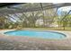 Inviting screened-in pool area features brick pavers, a waterfall feature, and ample seating at 1902 Sweet Bay Ct, Plant City, FL 33566