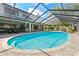Refreshing pool with brick paving, rock waterfall feature, and screened enclosure, perfect for outdoor enjoyment at 1902 Sweet Bay Ct, Plant City, FL 33566