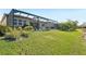 Backyard with screened-in patio, pool and landscaped green lawn at 20237 Bandera Pl, Venice, FL 34293