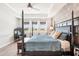 Luxurious main bedroom featuring a four-poster bed, tray ceiling, and serene views at 20237 Bandera Pl, Venice, FL 34293