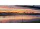 Picturesque sunset reflecting on the pond, with neighborhood homes in the background at 20237 Bandera Pl, Venice, FL 34293