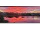 Vibrant sunset colors reflected in the pond, showcasing the neighborhood's beauty at 20237 Bandera Pl, Venice, FL 34293