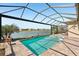 Inviting screened-in pool overlooking a scenic lake with ample seating at 20237 Bandera Pl, Venice, FL 34293