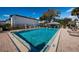 Large community pool surrounded by lounge chairs and mature landscaping; the ultimate relaxation at 256 Cypress Ln # 120, Oldsmar, FL 34677