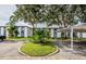 Exterior view of the building and parking area, surrounded by mature trees at 256 Cypress Ln # 120, Oldsmar, FL 34677