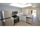 Open kitchen with stainless steel appliances and gray cabinets, flowing into the living area at 256 Cypress Ln # 120, Oldsmar, FL 34677