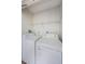 Bright laundry room featuring a white washer and dryer set, with storage shelf above at 256 Cypress Ln # 120, Oldsmar, FL 34677