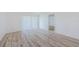 Sunlit living room showcasing the new, light-colored hardwood floors, vertical blinds, and freshly painted white walls at 256 Cypress Ln # 120, Oldsmar, FL 34677