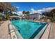 Community pool with lounge chairs, an outdoor bar, and a building on a sunny day at 256 Cypress Ln # 120, Oldsmar, FL 34677