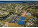 Community aerial view showcasing a golf course, waterways, tennis courts, clubhouse, and pool, surrounded by lush greenery at 2731 Sherbrooke Ln # D, Palm Harbor, FL 34684