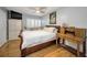 Cozy bedroom featuring a ceiling fan, hardwood floors, and a vintage wooden desk at 2731 Sherbrooke Ln # D, Palm Harbor, FL 34684