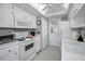 Well-lit white kitchen with white appliances at 2731 Sherbrooke Ln # D, Palm Harbor, FL 34684